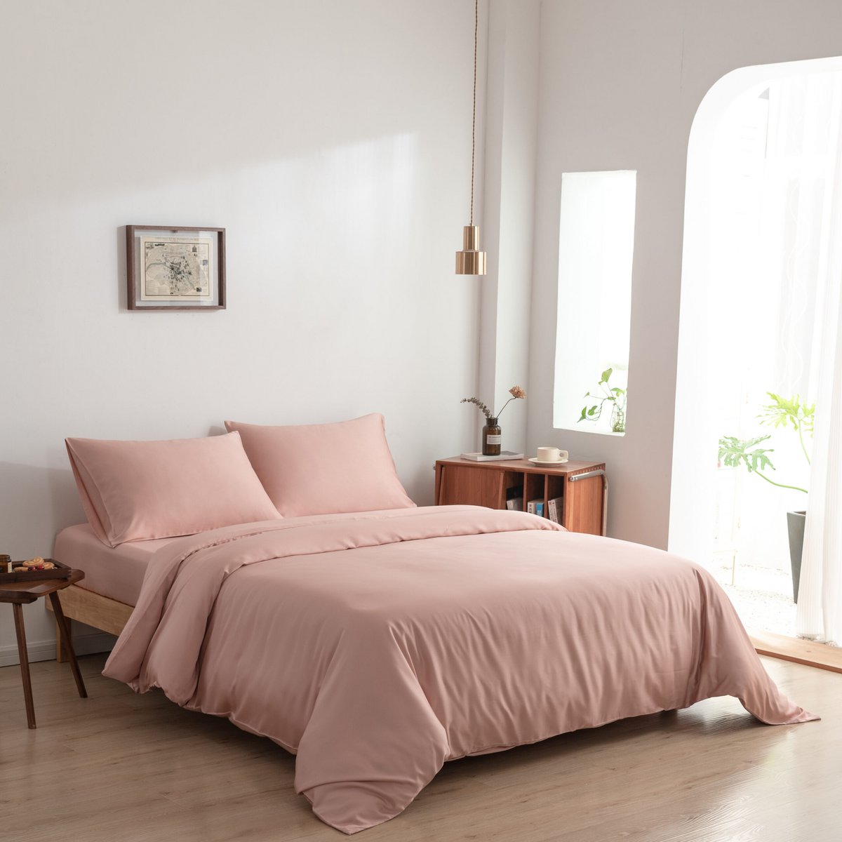 Bamboo duvet cover in Cuddle Pink on a bed near an arched window with sheer curtains and plants