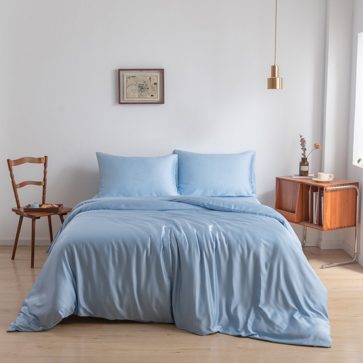 Bamboo duvet cover in Sky Blue on a bed beside a wooden chair in a bright bedroom