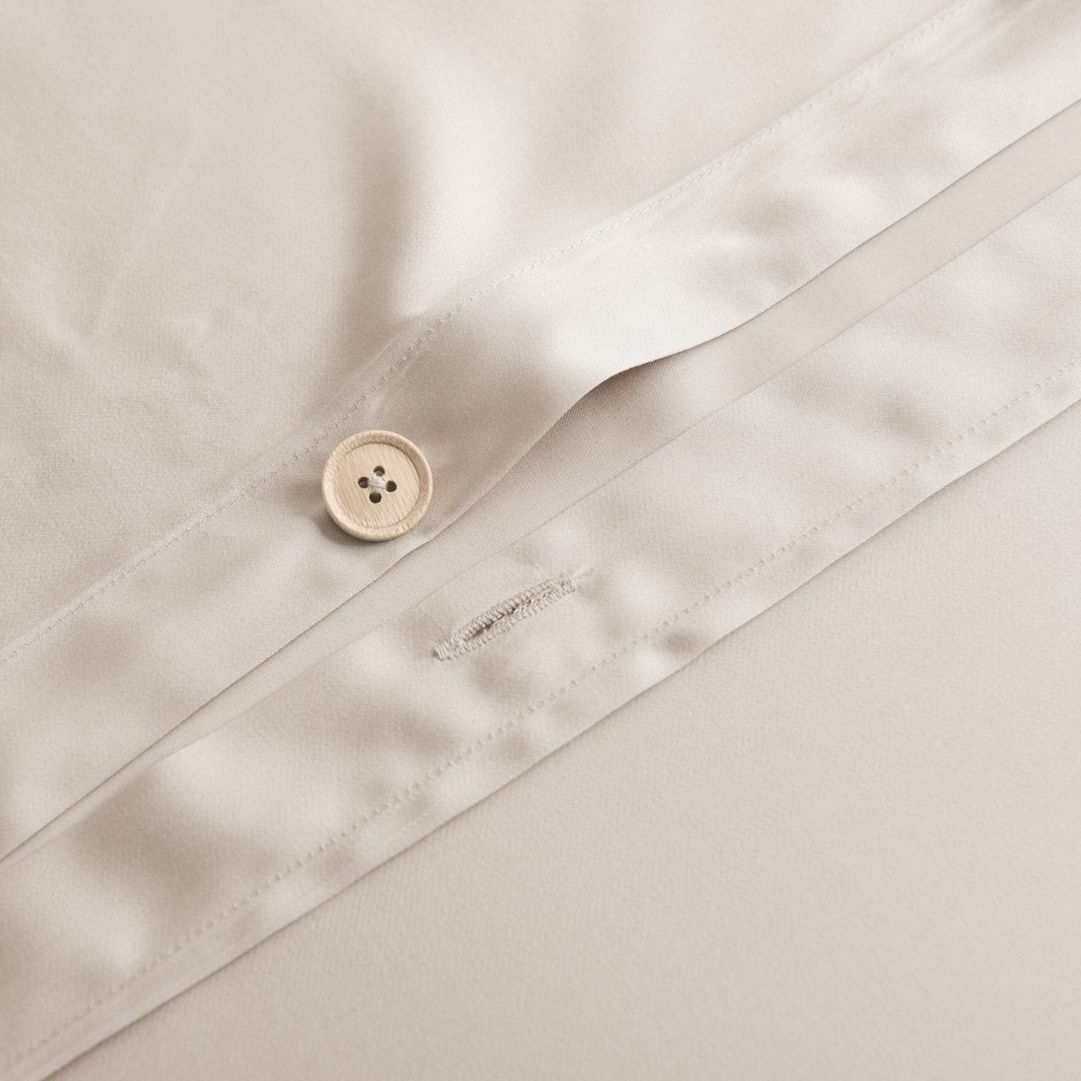 Close-up of a handmade bamboo button and buttonhole closure on the Soft Taupe bamboo duvet cover