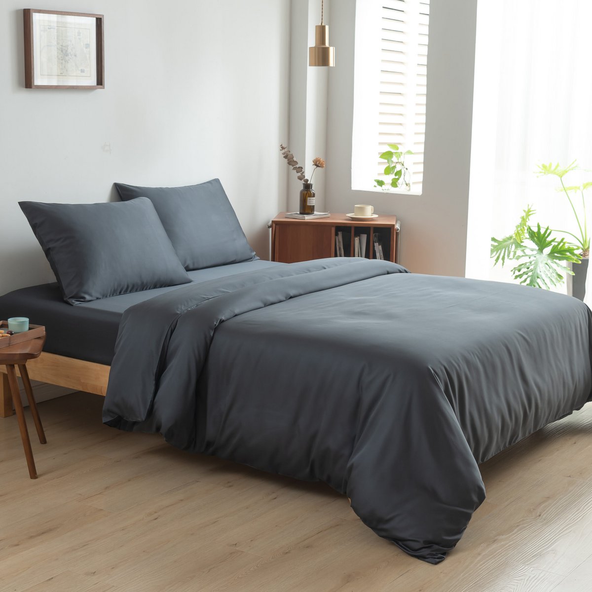 Bamboo duvet cover in Space Blue on a bed with a folded throw blanket in a bright bedroom