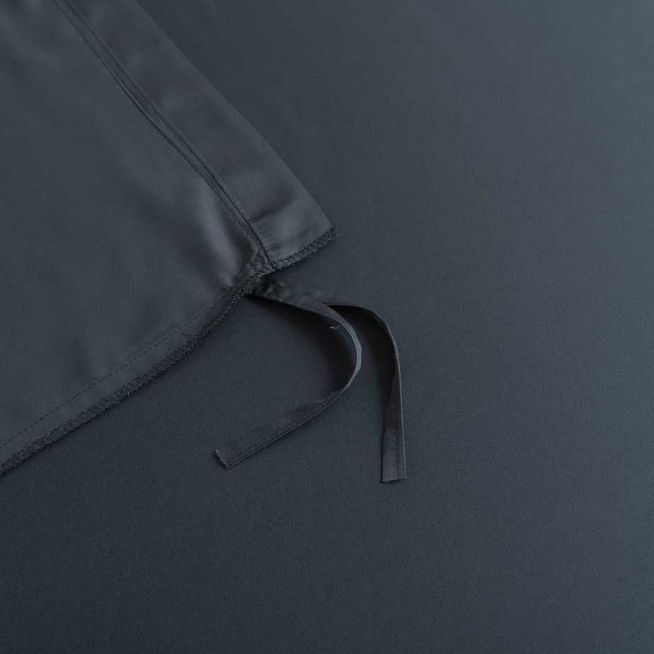 Close-up of the tuck-in strip ties on the corner of the Space Blue bamboo duvet cover