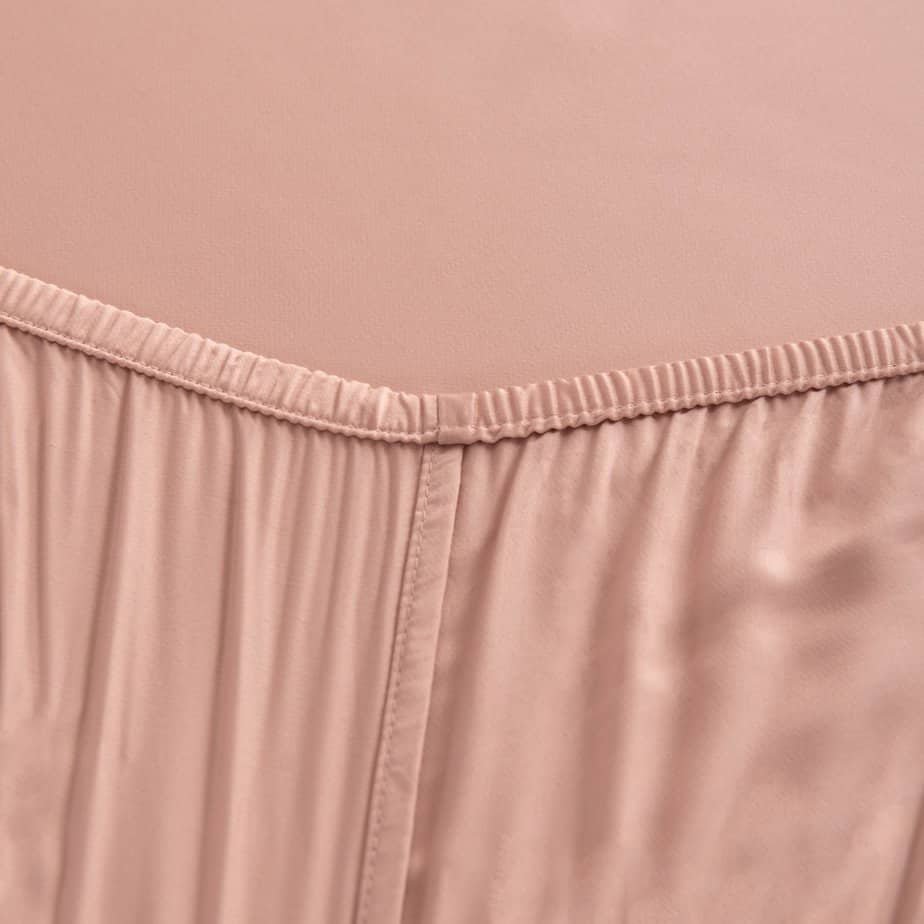 Close-up of the Cuddle Pink bamboo fitted sheet's elasticated corner seam.