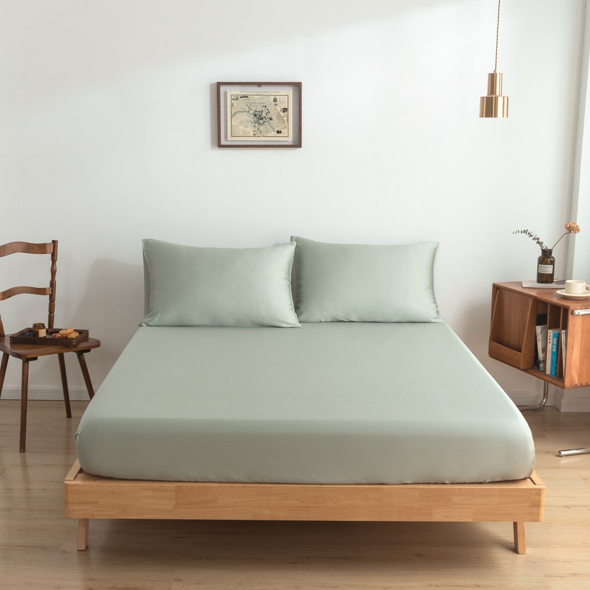 Sage Green bamboo fitted sheet on a made bed, shown straight-on with two matching pillows.