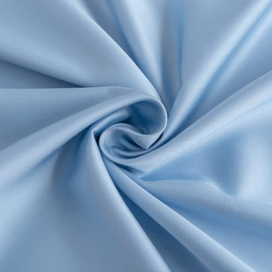 Close-up of swirled Sky Blue bamboo fabric showing its smooth, silky texture.