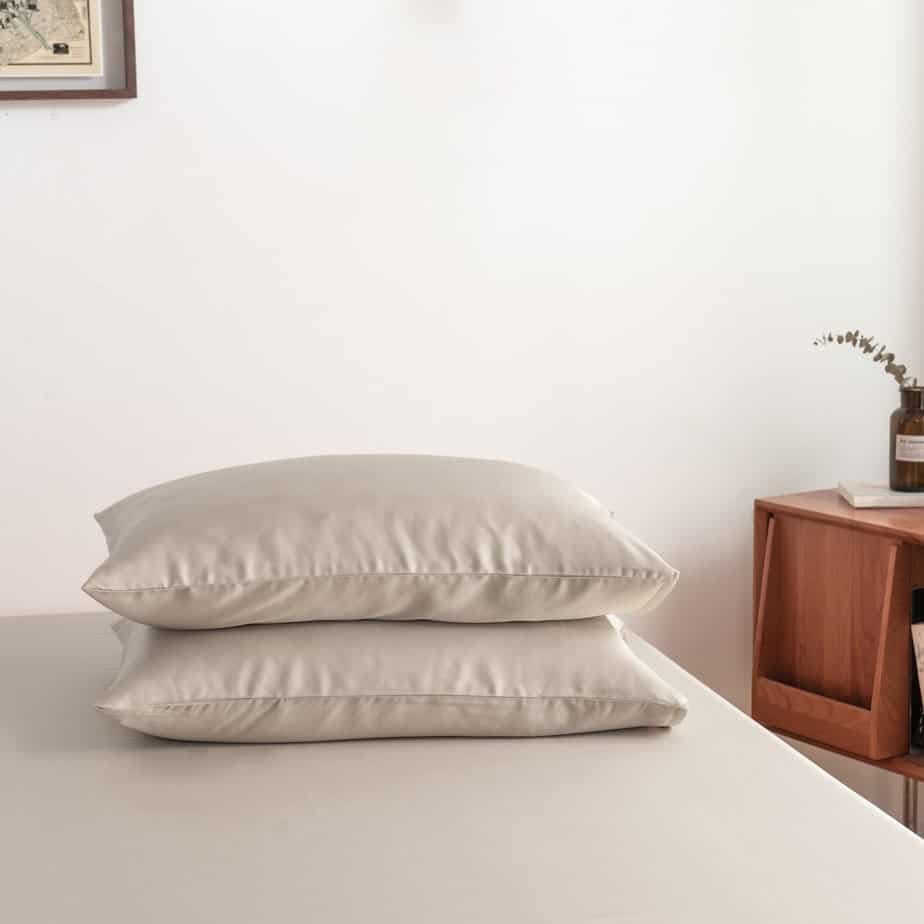 Soft Taupe bamboo pillowcases styled on a bench in a bedroom setting
