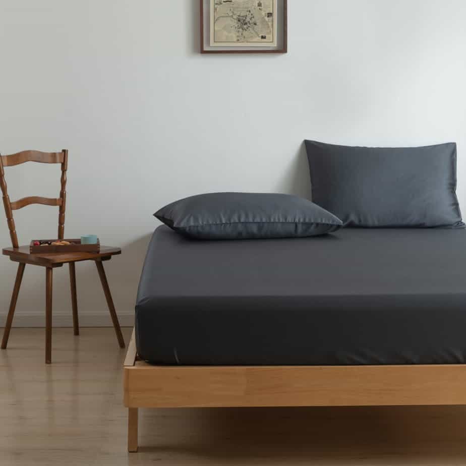 Space Blue bamboo pillowcases on a wood-framed bed
