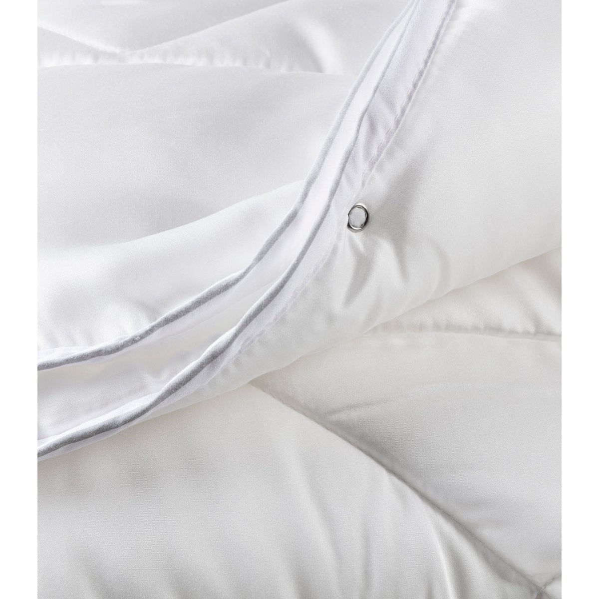 Close-up of the metal press-stud eyelet on the Tencel satin Super Soft Duo duvet used to connect the two layers