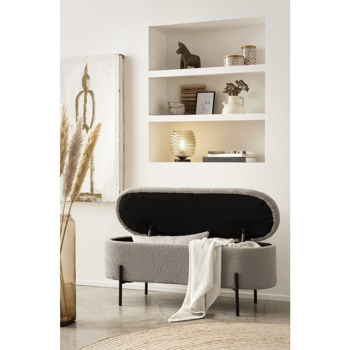 Banc de lit avec rangement en bouclé taupe avec couvercle ouvert et un plaid posé sur le bord