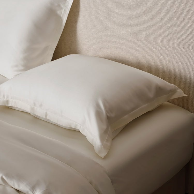 Close-up of the Tencel™ Sateen Duvet Cover in Off White showing the pillow and duvet edge on a bed
