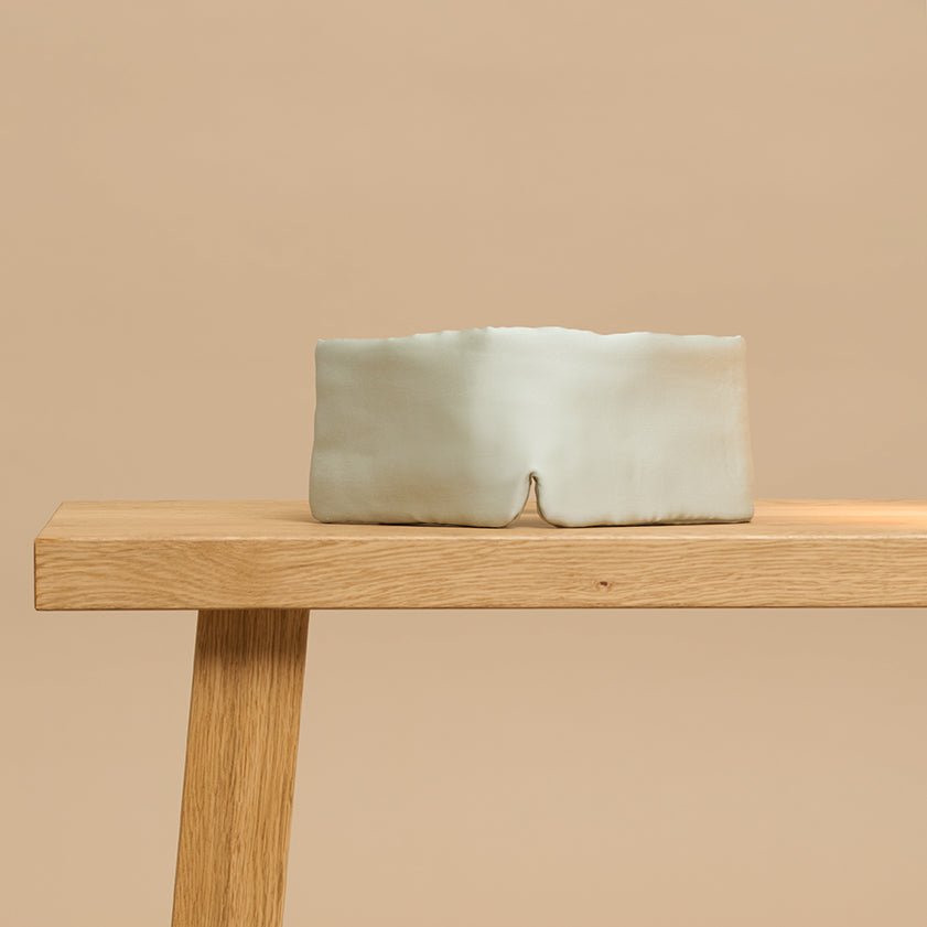 Gray Green sleeping mask on a wooden bench