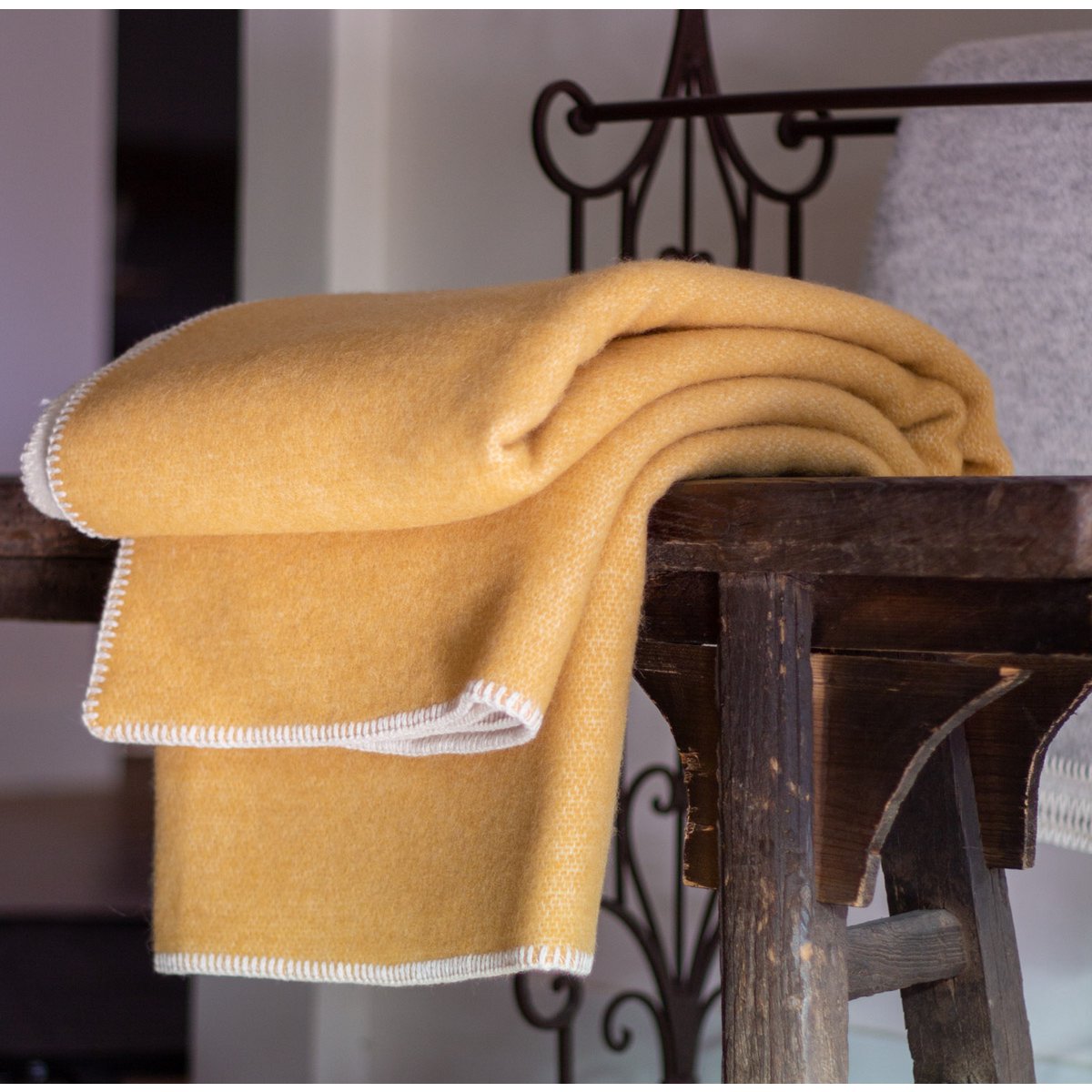 Woolen Throw Blanket Misted Yellow styled on a bed