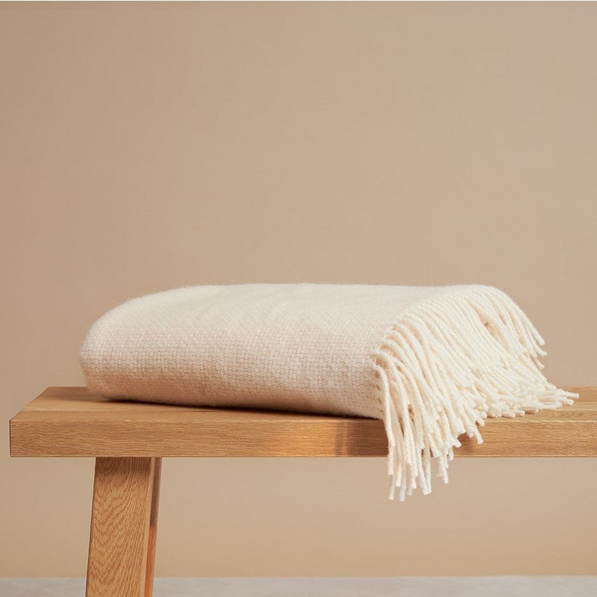 Alpaca Merino Throw Blanket folded on a wooden bench