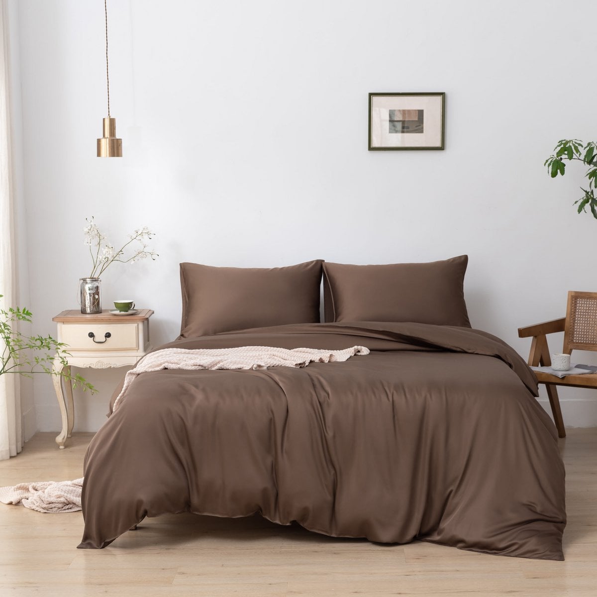 Bamboo duvet cover in Coffee Brown on a bed with a folded throw blanket and a wooden nightstand