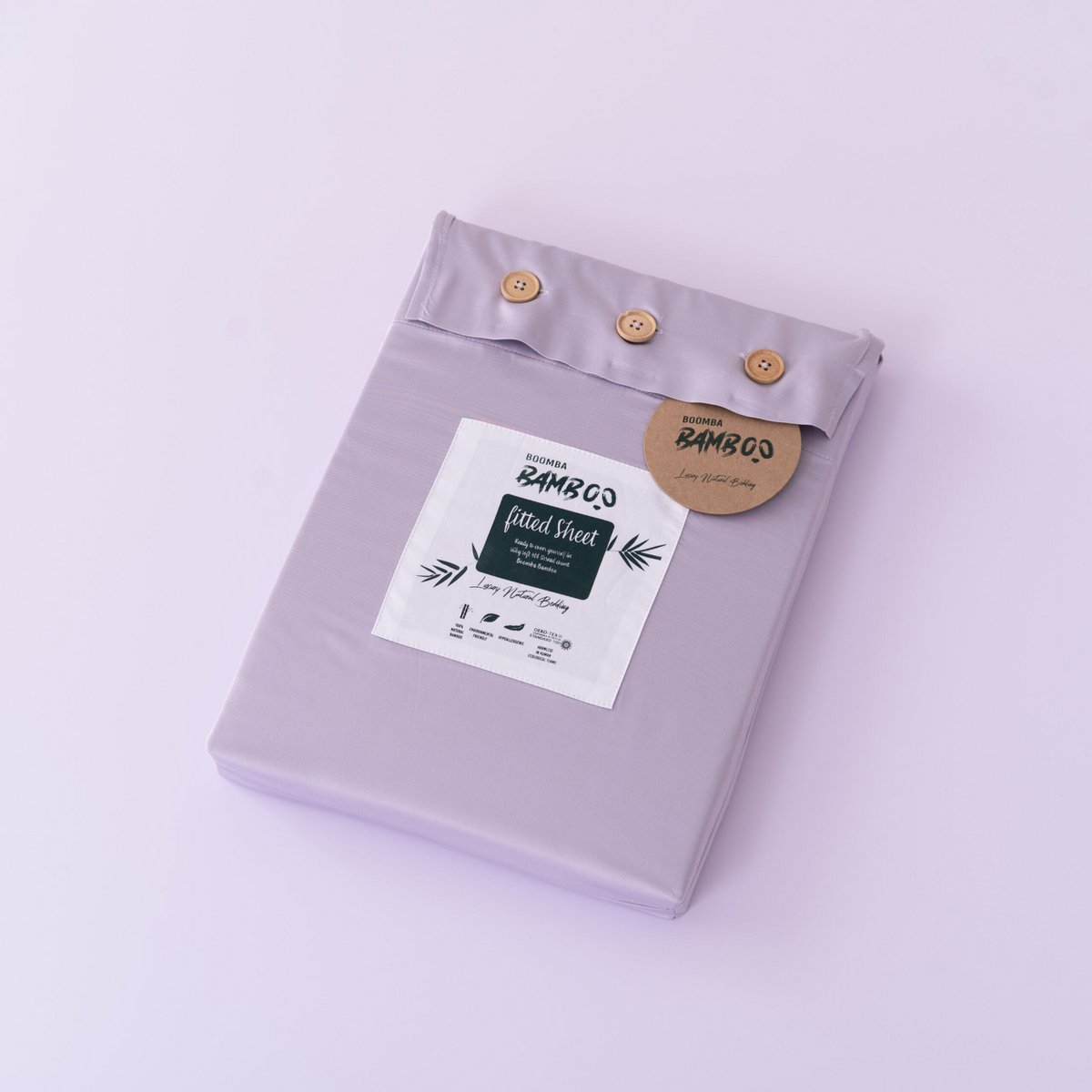 Lavender Mist bamboo fitted sheet for mattress toppers folded and packaged with the Boomba Bamboo product label.