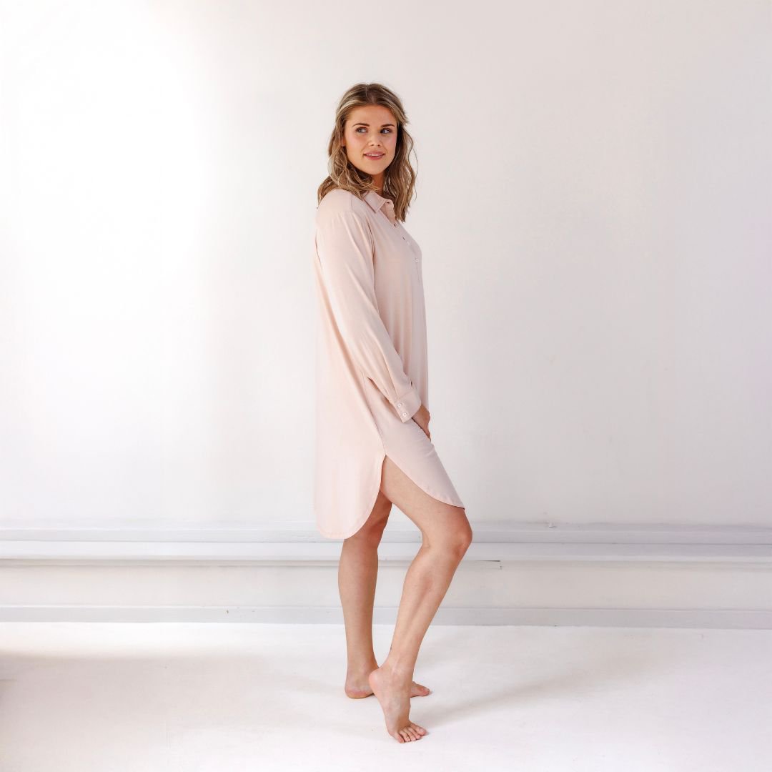 Woman in the Powder Peach nightgown seen from the side, showing the curved hem