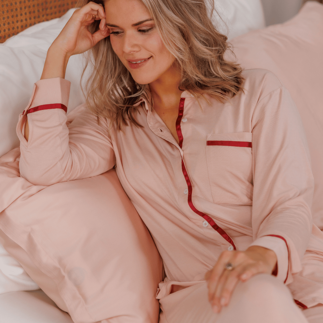 Woman leaning on a pillow in the Powder Peach pyjama set