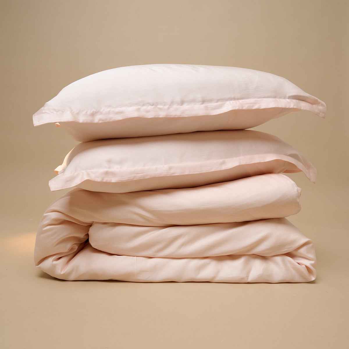 Tencel™ Sateen Duvet Cover and pillows in Peach White, folded