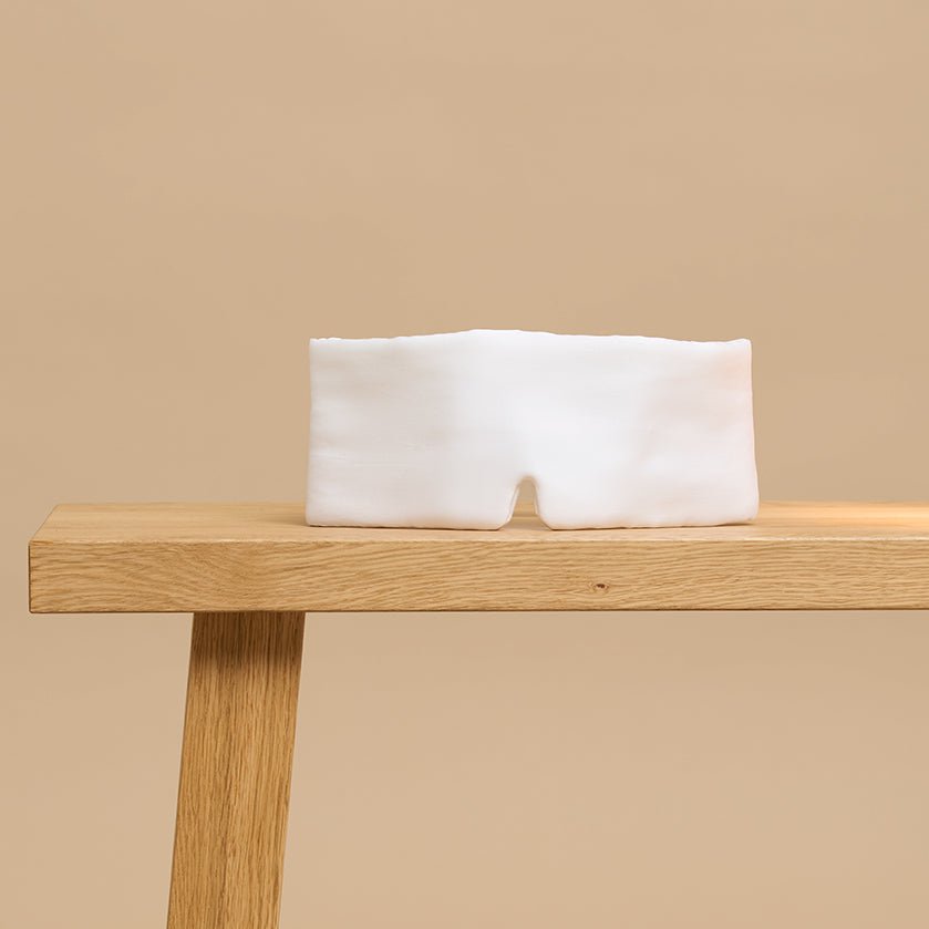 White sleeping mask on a wooden bench